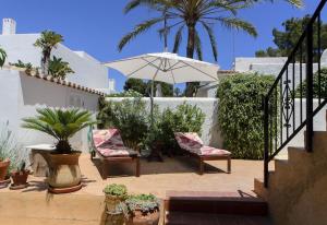 a patio with two chairs and an umbrella at Vista Bahía in Moraira