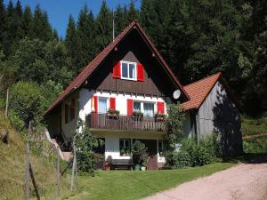 a house with red shutters and a balcony at Rinkenbachhof in Schenkenzell