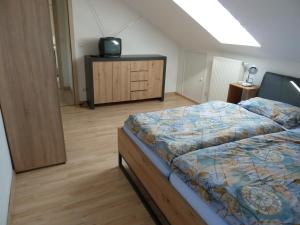 a bedroom with a bed and a tv on a dresser at Haus Bergblick 1 in Utzmemmingen