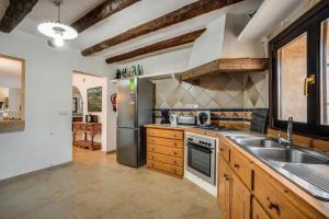 a kitchen with a stainless steel refrigerator and a sink at Finca Can Moleta in Cala Mendia