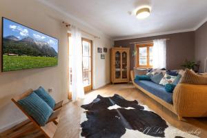 a living room with a blue couch and a tv at Ferienwohnung Bienennest in Mittenwald