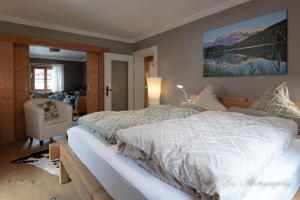 a bedroom with a large bed and a chair at Ferienwohnung Bienennest in Mittenwald