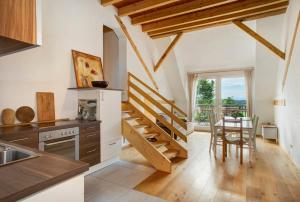 a kitchen with wooden stairs and a table with chairs at Hof Sinnenberg in Deggenhausertal