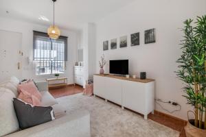 a living room with a couch and a flat screen tv at Villa Marília in Ayamonte