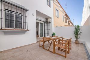 a patio with a wooden table and two chairs at Villa Marília in Ayamonte