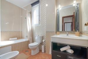 a bathroom with a toilet and a sink and a mirror at Villa Marília in Ayamonte +19 photos