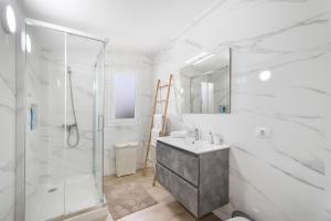 a white bathroom with a shower and a sink at Casa Mar Azul in Frontera +15 photos