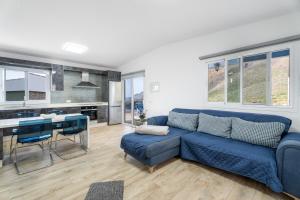 a living room with a blue couch and a kitchen at Casa Mar Azul in Frontera
