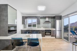 a kitchen with a white table and blue chairs at Casa Mar Azul in Frontera