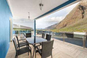 a dining room with a table and chairs on a balcony at Casa Mar Azul in Frontera