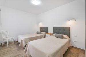 a room with two beds and a chair at Casa Mar Azul in Frontera