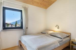 a bedroom with a bed and a window at Stackler54 - mit Balkon in Neustift im Stubaital