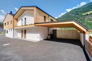 a house with a garage with a roof at Stackler54 - mit Balkon in Neustift im Stubaital