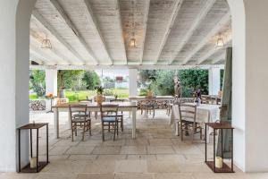 an outdoor dining area with tables and chairs at L'aia di San Giorgio in Ortelle