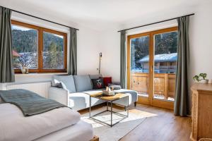 a living room with a couch and a table at Fewo Am Steinbach - Stoaboch in Reit im Winkl