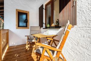 a wooden table and chairs on the balcony of a house at Fewo Am Steinbach - Stoaboch in Reit im Winkl +20 photos