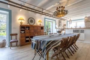 a dining room with a table with chairs and a clock at La bonne descente in Fouesnant +27 photos