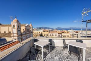a balcony with tables and chairs and a view of a city at Disiu Case Vacanza - Balestrate in Balestrate