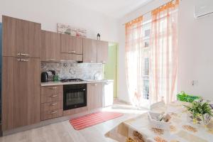 a kitchen with wooden cabinets and a large window at Disiu Case Vacanza - Balestrate in Balestrate +18 photos
