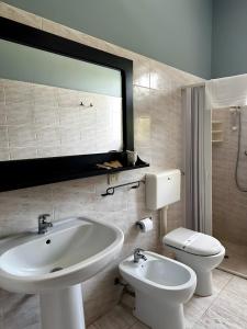a bathroom with a white sink and a toilet at L'aia di San Giorgio in Ortelle +58 photos