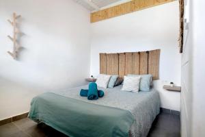 a bedroom with a bed with a blue stuffed animal on it at Suite Amanecer in Mácher +12 photos