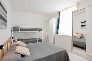 a bedroom with two bunk beds and a mirror at Bilocale Mezzano in centro in Varazze