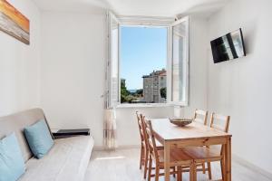 a living room with a table and a couch and a window at Bilocale Mezzano in centro in Varazze