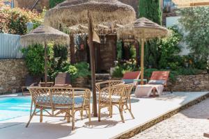 a group of chairs and umbrellas next to a pool at Casa Douro Janja in Armamar