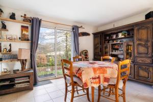 a dining room with a table and chairs and a window at Les chambres de Florence in Saint-Jouan-de-lʼIsle