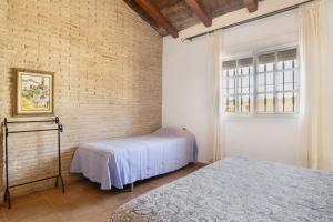 a bedroom with two beds and a brick wall at Casa Altamar in Barbate +20 photos