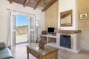 a living room with a fireplace and a tv at Casa Altamar in Barbate