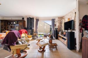 a living room with many chairs and a tv at Les chambres de Florence in Saint-Jouan-de-lʼIsle