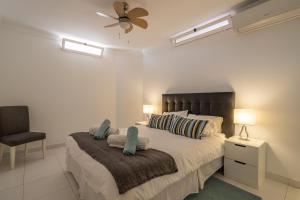 a bedroom with a bed with a fan and a chair at Casa Chloe in Nerja +26 photos