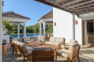 a patio with a table and chairs and a pool at Villa Lara in Benalup Casas Viejas