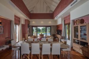 a dining room with a large wooden table and white chairs at Villa Lara in Benalup Casas Viejas