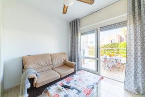 a living room with a couch and a large window at Gaviotas 4 in Aguadulce +13 photos