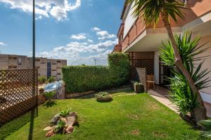 a yard with a palm tree and a building at Casa Michelle in Villaputzu