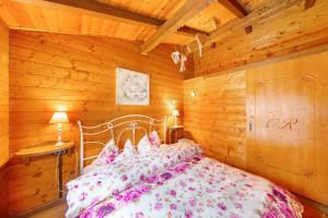a bedroom with a bed and a wooden wall at Orserose Chalet 5 I Fus in Forno di Zoldo +3 photos
