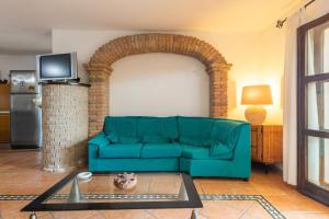 a living room with a blue couch and an archway at Casa Michelle in Villaputzu