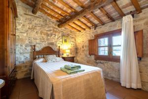 a bedroom with a bed in a stone wall at El Clos 3 in Conesa +24 photos