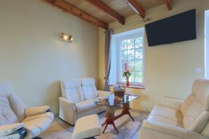 a living room with white furniture and a flat screen tv at Le paradis sur mer in Paimpol