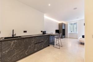 a kitchen with a counter top and a living room at App 203 Palazzo Cavour in Bolzano