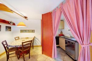 a kitchen and dining room with a table and a pink curtain at The Waterfall Chalet in La Salle