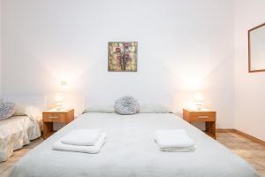 a bedroom with a large bed with two night stands at Gerani Rossi Appartamento in Villa San Pietro