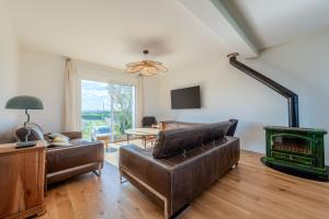 a living room with a couch and a stove at Maison Stoubenn in Kerlouan