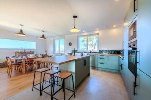 a kitchen with a large island with stools at Maison Stoubenn in Kerlouan