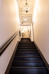 a staircase in a building with a chandelier at Heritage Collection on Victoria - Mobile App Check-In in Singapore