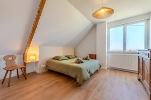 a bedroom with a bed and a large window at Maison Stoubenn in Kerlouan