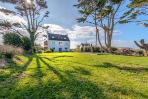 a house on a grassy hill with trees at Maison Stoubenn in Kerlouan
