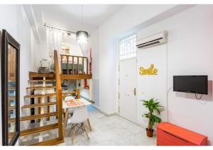 a room with a staircase and a table and a tv at Duplex Seville-Historic Center in Seville +17 photos